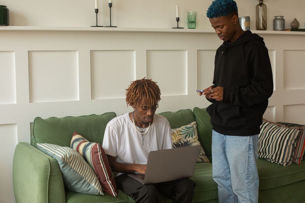 Property Scams Are Moving Online, and Diaspora Buyers Are the Easiest Targets man seated on a couch using laptop