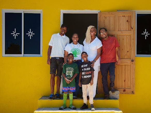 Theodore Notise and his twin sons with GrassROOTS Community Foundation officials, Senator Allan Bernard and a Flanker Resource Centre representative at the home handover in Flanker, St James