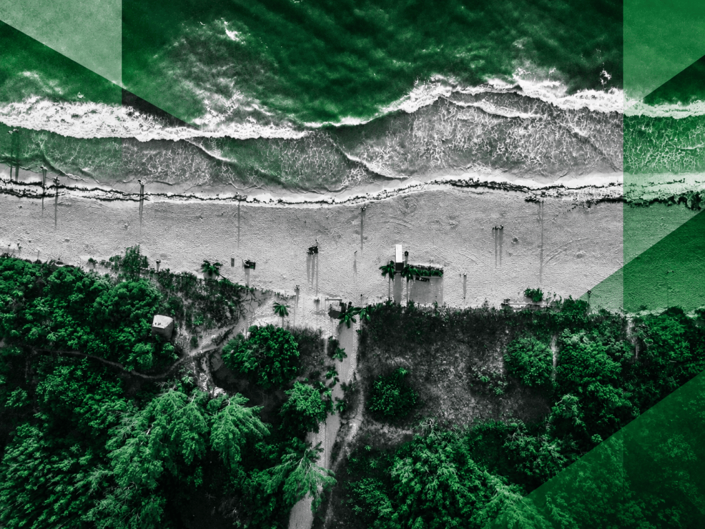 A dramatic aerial view of Jamaica’s coastline, reimagined in Jamaica Homes News’ signature green-and-grey style, highlighting the close relationship between land, development and the sea.