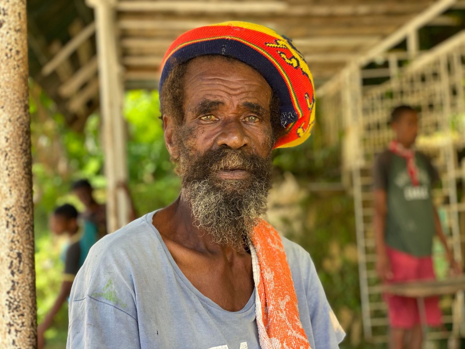 elderly rasta man with facial hair wearing a rasta tam hat - Photo by Dewnette Reid