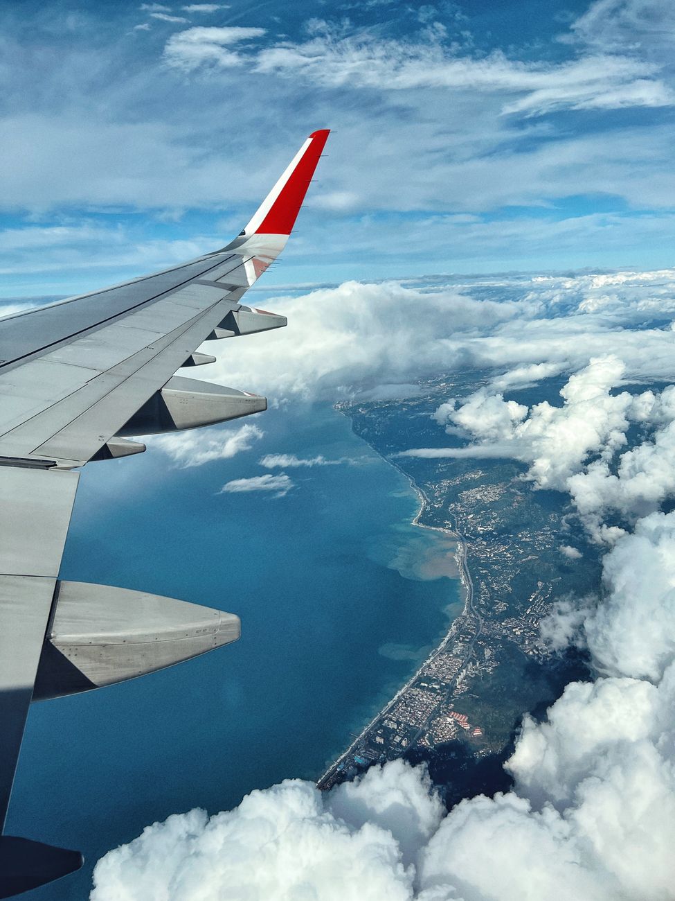 airplane wing over white clouds