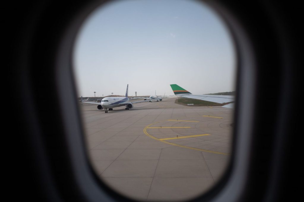 planes on airport runway view through a porthole