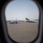 planes on airport runway view through a porthole