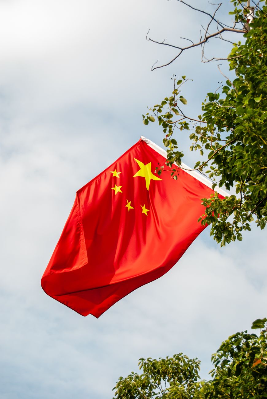 chinese national flag flying in shenzhen china Photo by Da Na
