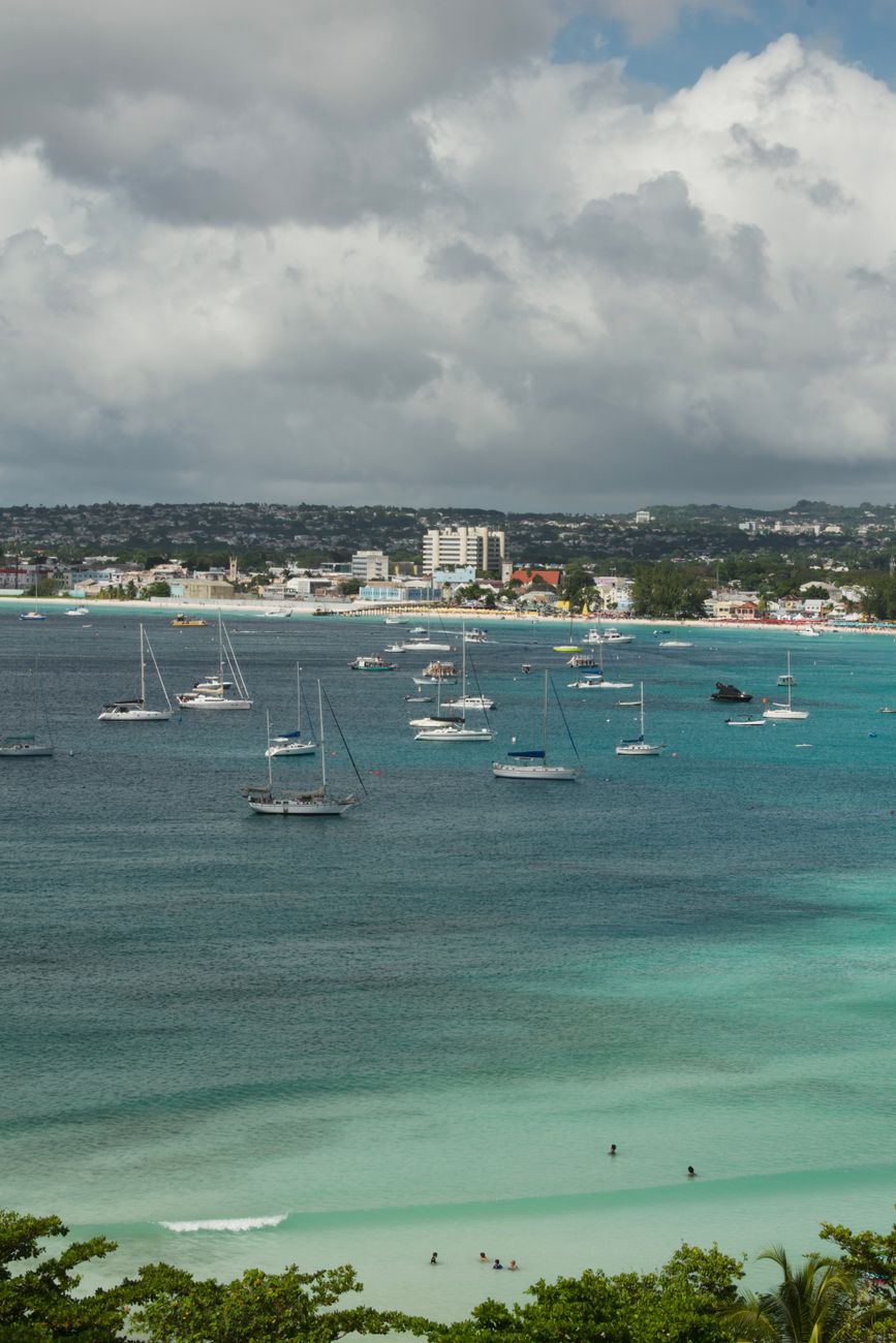 stunning tropical bay with sailboats and townscape - Photo by Mariya Eskina