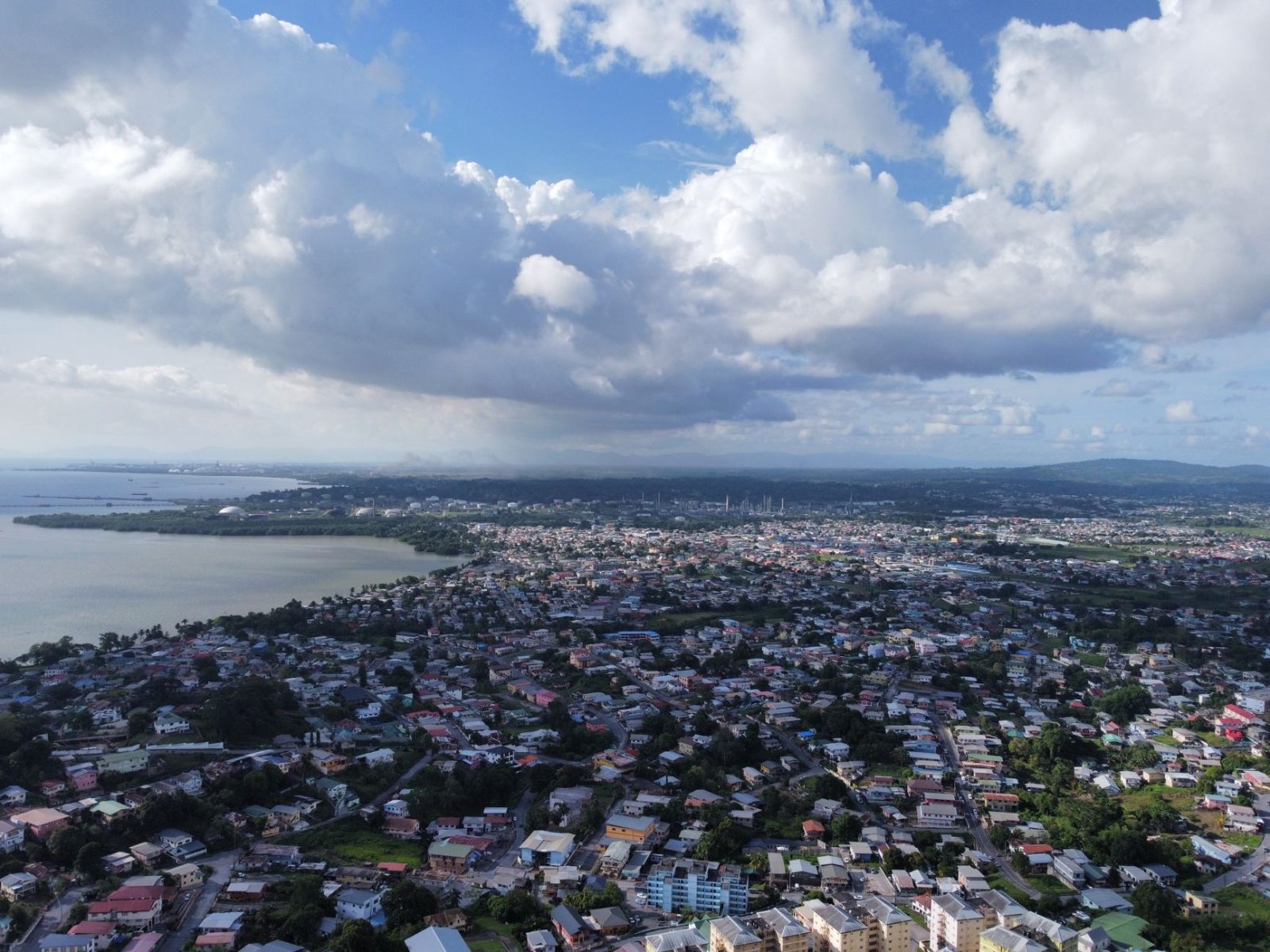 aerial view of a coastal cityscape under blue sky - Photo by Anderson Jagradatt