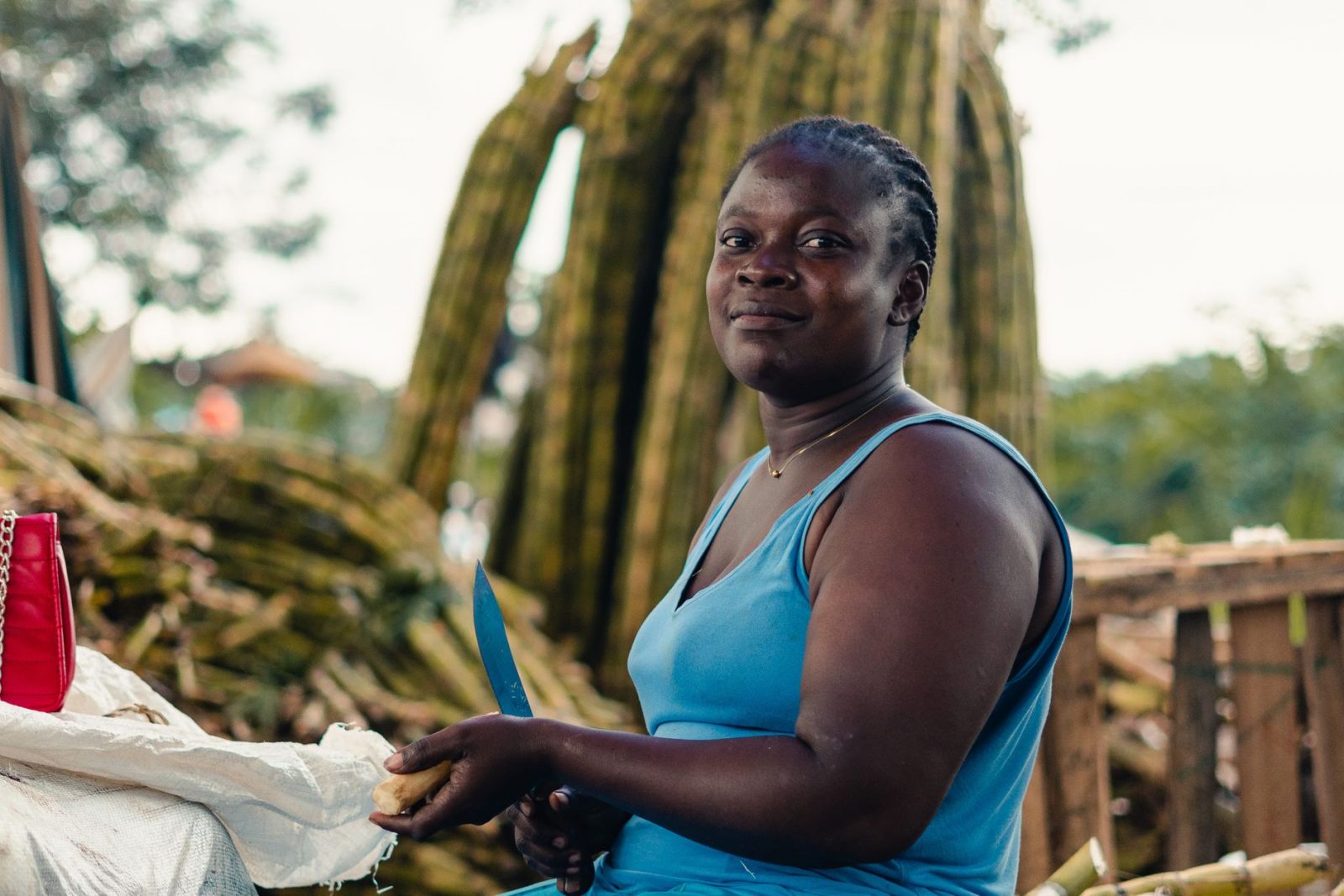 african woman preparing food outdoors with knife