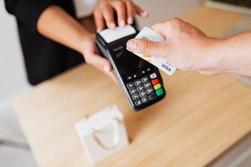 Jamaica’s J$94-Billion Credit-Card Trap Is Built to Keep People Paying a person paying cashless using credit card