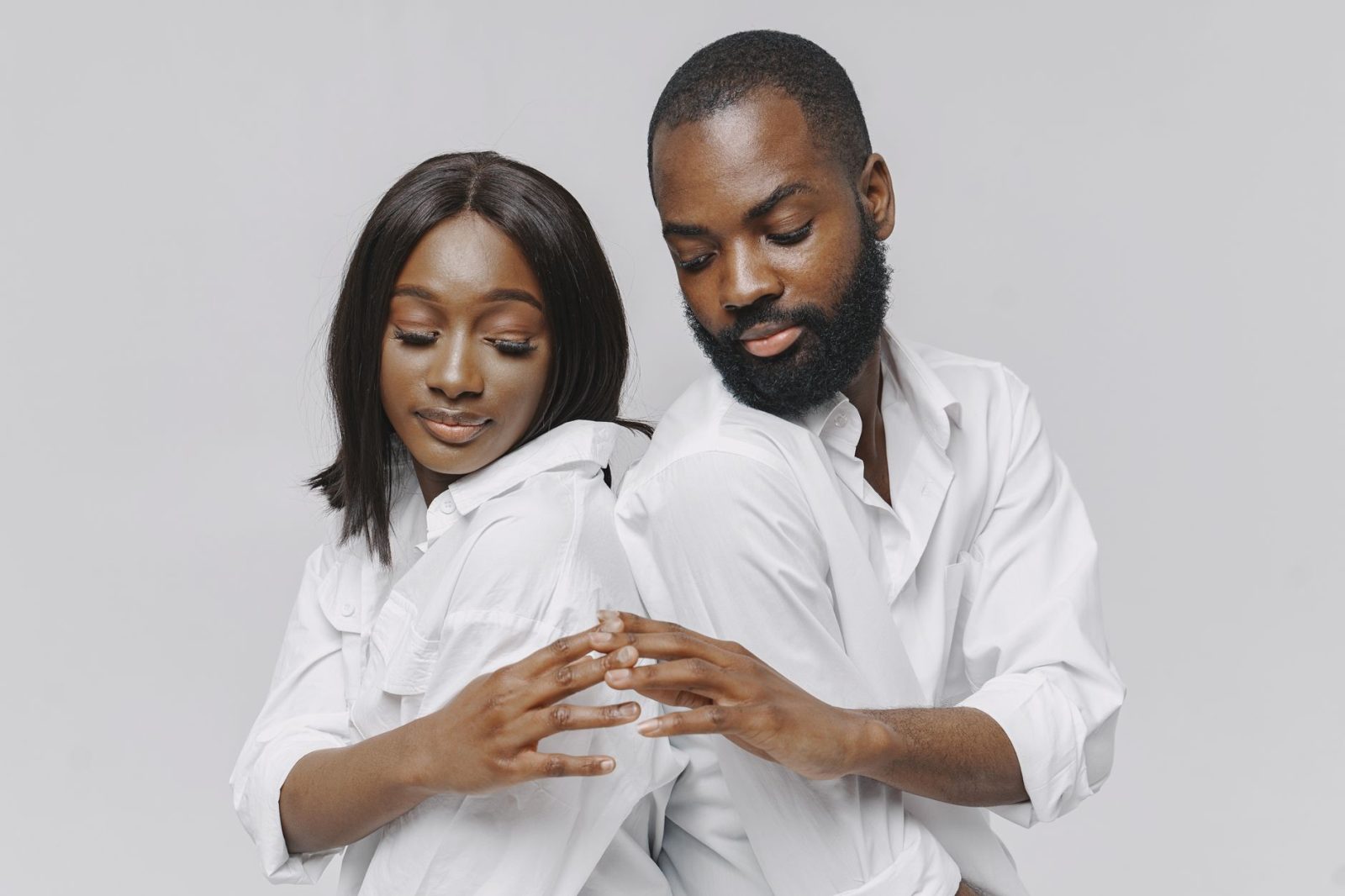 a couple in white long sleeves touching hands