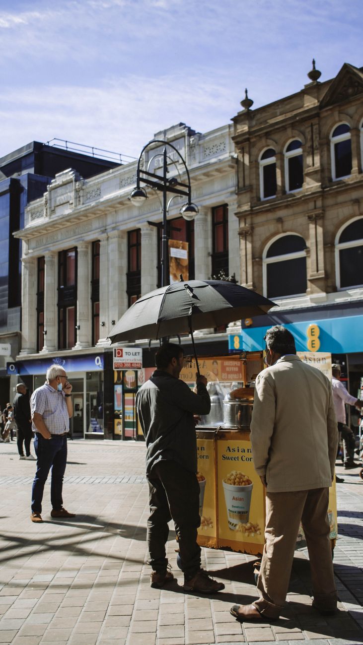 photograph of men buying from a street vendor